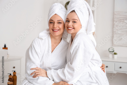 Young woman with her mother after shower hugging in bathroom