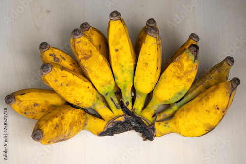 A bunch of yellow ripe bananas on a wooden background. Bananas are a nutritious fruit that has many health benefits.