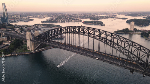 Aerial drone view of Sydney Harbour Bridge, NSW Australia showing two trains crossing the bridge during an early morning sunrise in March 2024 