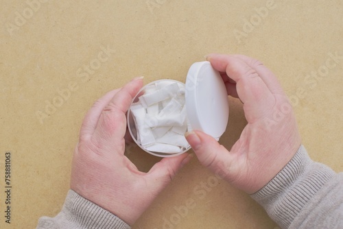 A woman holds a box of snus pads, a substitute for smokeless cigarettes. 