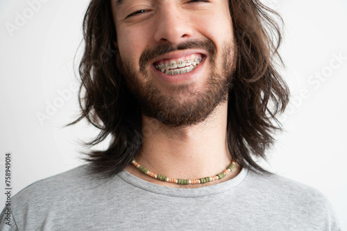 close up of a young latin man with braces wearing a colorful ceramic necklace