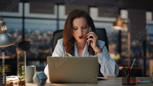 Woman having business call writing notes at office. Smiling lady boss talking