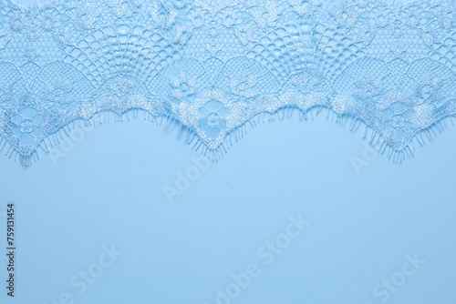 Beautiful lace on light blue background, top view. Space for text