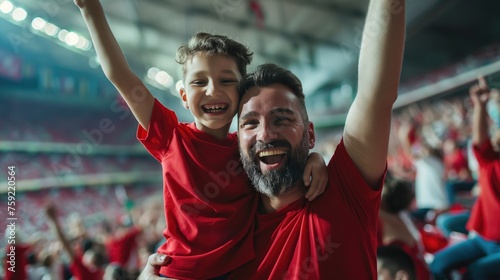 Cheerful father and son cheer for their favorite team on the football stadium. Football concept 