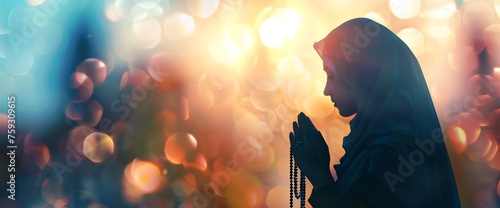 Silhouette of a Muslim woman holding a rosary and praying with a blurred natural background for a religious