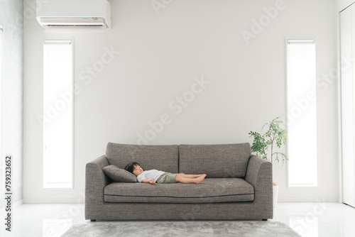 家のソファで寝るアジア人の子供（男の子・熟睡・睡眠・眠る・お昼寝） 