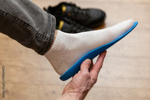 Close up of man hands fitting orthopedic insoles.