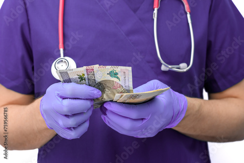 Lekarz chirurg liczy gotówkę w rękawiczkach 