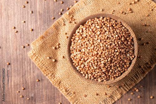 Buckwheat groats on wooden background. Healthy cereal concept. 