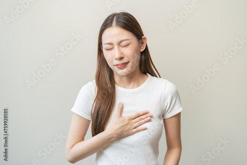 Acid reflux disease, suffer asian young woman have symptom gastroesophageal, esophageal, stomach ache and heartburn pain hand on chest from digestion problem after eat food