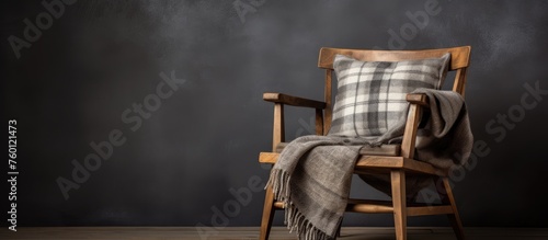 A wooden chair with a plaid pillow and blanket sits on the hardwood flooring, adding a cozy touch to the rooms decor