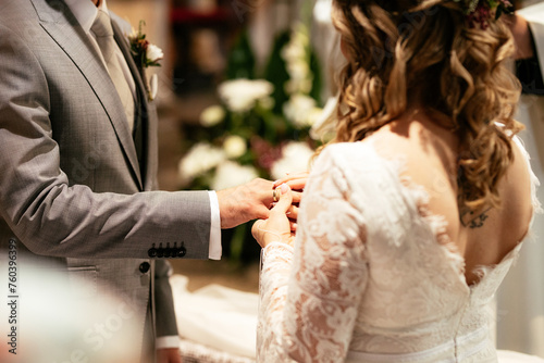 Exchange of wedding rings in a church couple holding hands during catholic ceremony