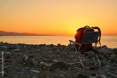 amanecer en la playa con una silla y una mochila