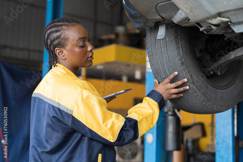 Female mechanic working at garage. Professional female mechanics checks, repair and maintenance tires car at auto car repair service. Car service and Maintenance concept