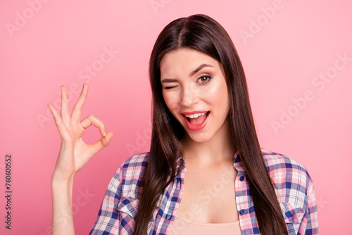 Close up photo amazing her she lady hold arm hand fingers okey symbol winking brown eyes long straight hair wear casual checkered plaid shirt clothes outfit isolated pink bright background