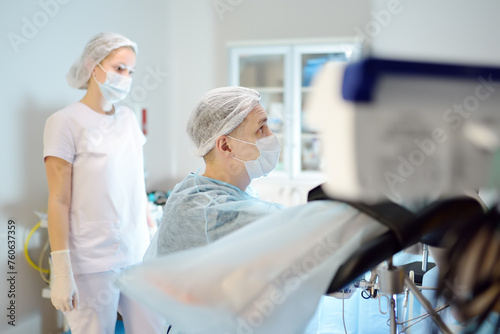 Gynecologist operation patient in gynecological chair. Doctor performs invasive medical procedure in modern hospital. Diagnosis and treatment of cervical cancer. Surgical removal of uterine cyst