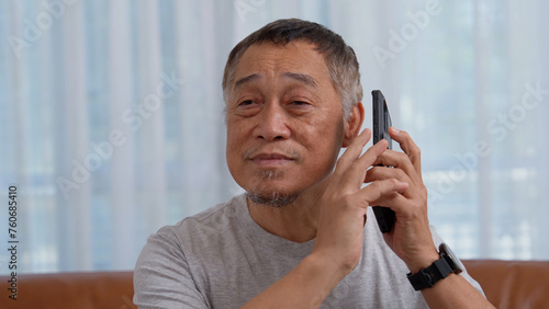 Blind Asian elderly men use digital assistant get ease of access functions on smartphone, Voice typing on phone. Person visually impaired and eye disease in the elderly Concept, Accessibility phone.