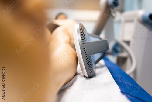 An adult man undergoes super inductive system therapy for recovery from trauma and rheumatic pathologies in a physiotherapy clinic.The handle is on the leg. Super Inductive System, SIS.