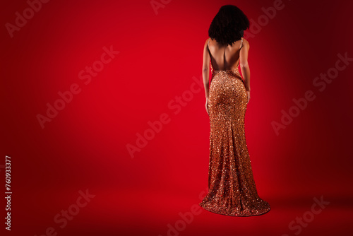 Photo of stunning fancy woman with bare back and slim sexy figure in sparkling dress on dark red color background