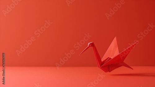 A delicate red origami crane positioned against a red background, artistic