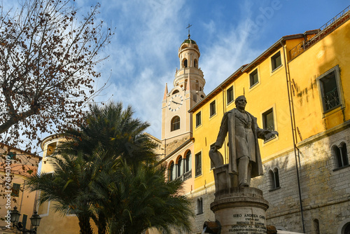 Piazza Eroi Sanremesi square with the statue to Siro Andrea Carli, mayor of the city, and the bell tower of the Co-Cathedral of San Siro in the background, Sanremo, Imperia, Liguria, Italy