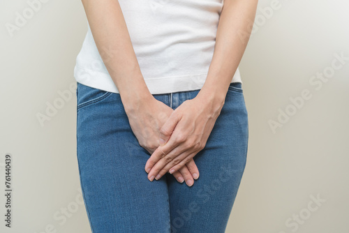 Vaginal, urinary incontinence. Pain asian young woman hand holding crotch suffering from pain, itchy or scratch of vagina, genital itching from infection. Gynecological problems menstrual disorder
