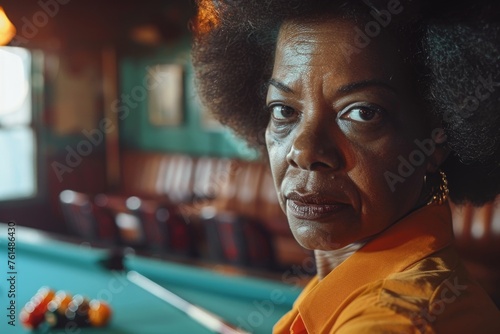 A woman in an orange shirt sitting in front of a pool table. Ideal for leisure and recreation concepts