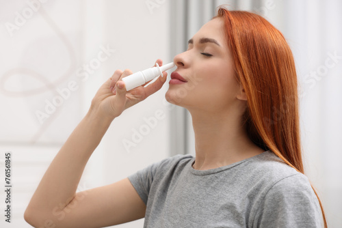 Medical drops. Woman using nasal spray at home