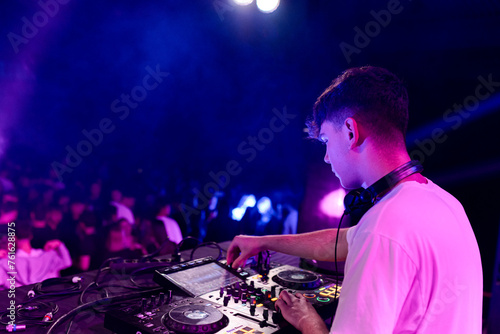 Rear side view of a dj working on a discotheque