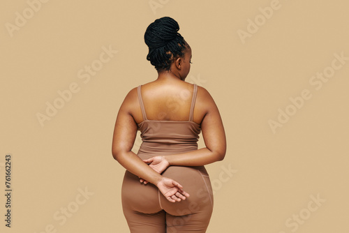 Studio portrait of curvy Black woman in sportswear, view from the back