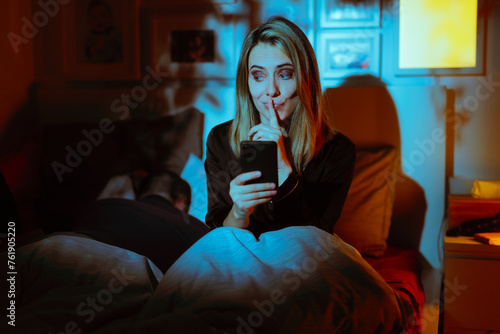 Woman Texting her Lover While her Husband is Asleep. Cheating girlfriend checking her dating app after her boyfriend falls asleep 