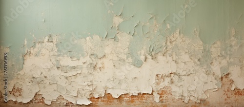 Shabby wall with remnants of green paint and torn brown wallpaper for interior renovation.