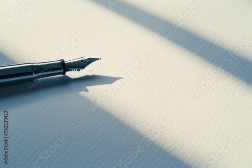 The long shadow of a fountain pen stretches across a blank page in the soft sunlight, evoking potential and inspiration.