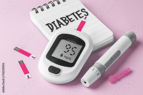 Glucometer, blood glucose sugar testing, diabetes concept on pink background