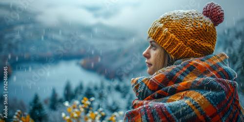 A person stands amidst falling snow, wrapped in a cozy plaid scarf and sporting a vibrant knit cap