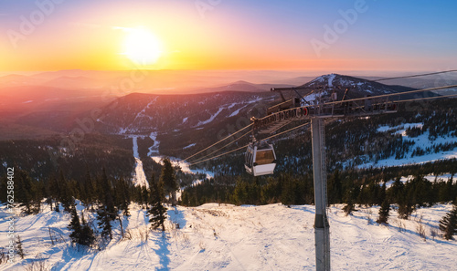 Aerial top view landscape ski lift resort with snowy forest on mountain in winter sunlight, Sheregesh, Kemerovo region Russia