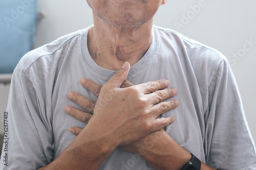 Hand of senior old man holding chest suffer from acid reflux, esophagus cancer chest