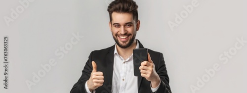 Satisfied business man showing thumbs up after using mobile phone, standing pleased over white background