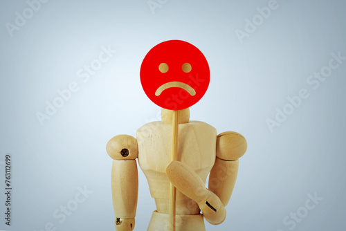 Wooden mannequin with sad face paddle - Concept of sadness, dissatisfaction and negative feedback