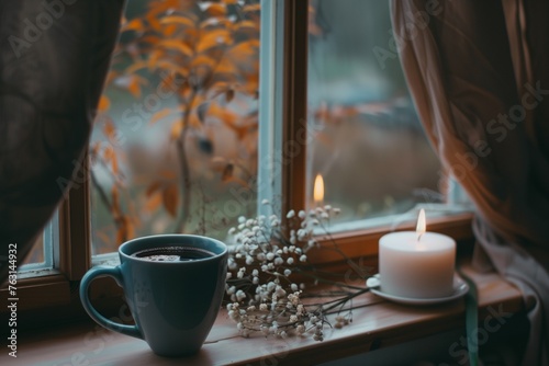 cup of coffee and white candle on the windowsill in autumn. 