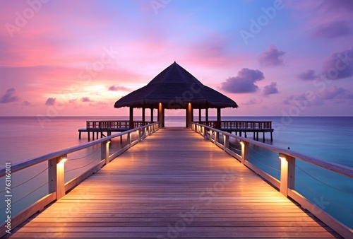 Wooden pier on tropical beach at sunset, Maldives island.