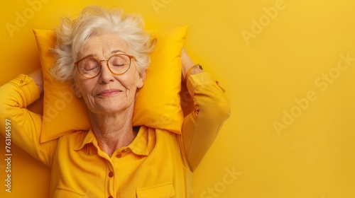 Elderly woman sleeping on pillow isolated on pastel yellow colored background Sleep deeply peacefully rest. Top above high angle view photo portrait of satisfied .senior wear yellow shirt