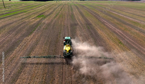 Spraying field. Tractor use spray and irrigation. Tractor spraying on field with sprayer trailer, herbicides and pesticides. Field spraying in farmland.