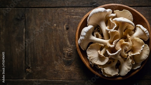 A bowl full of oyster mushrooms set against a dark, aged wooden background, highlighting organic culinary themes