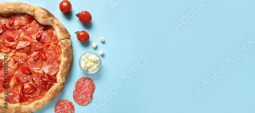 Delicious pepperoni pizza and ingredients on light blue background with space for text, top view