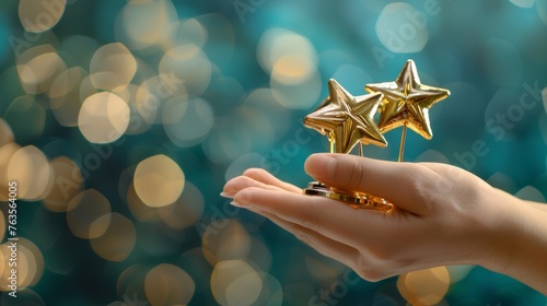 A hand gesture holding five golden star awards, representing success in business or the recognition of personal talent