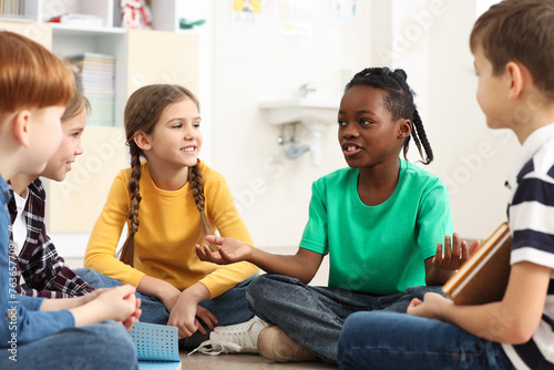 Cute children discussing in classroom at school