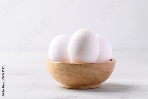 Organic white leghorn egg from free range farm in wooden bowl