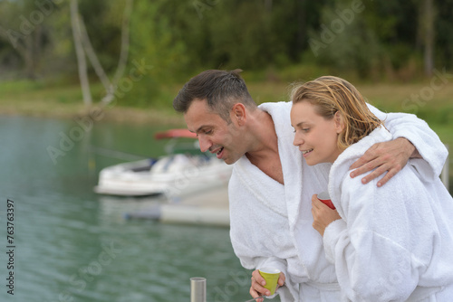senior couple in bathrobe sitting on a pontoon