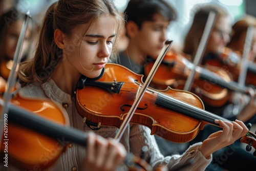 Young violinist concentrating intensely while performing in an orchestra setting